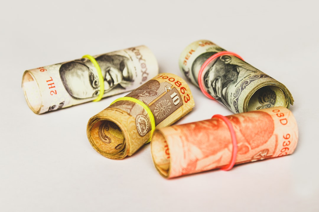 Rolled banknotes bound with rubber bands on a white surface