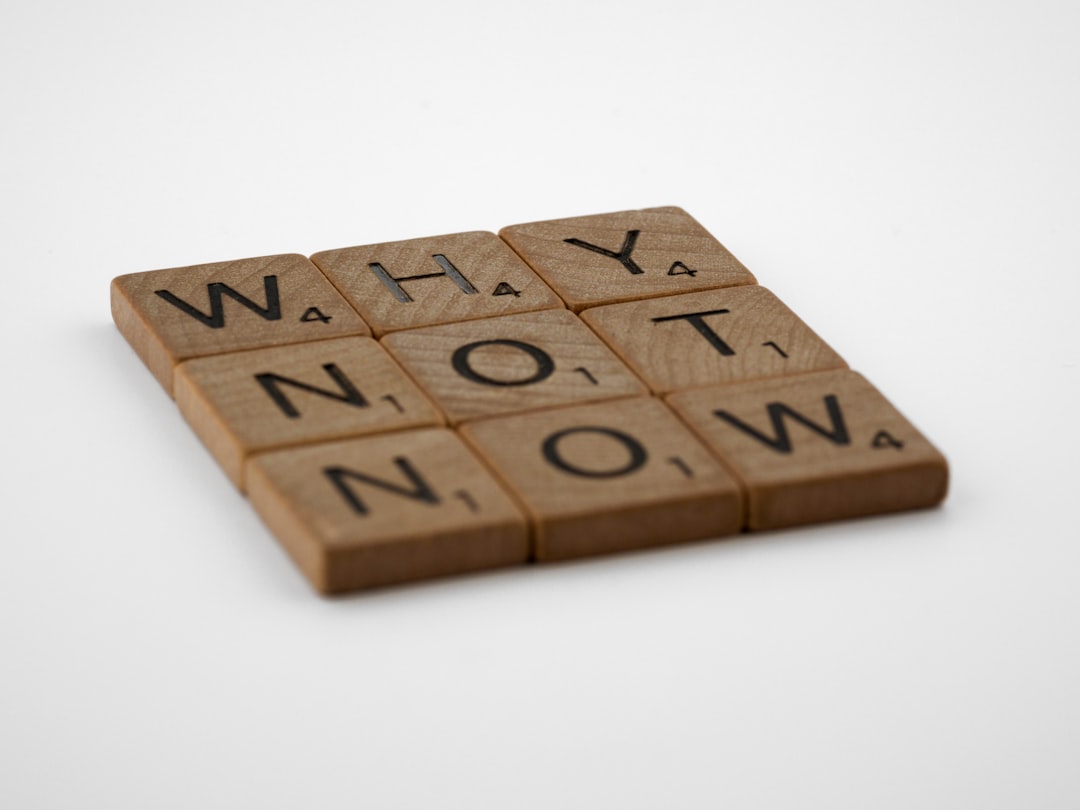Scrabble tiles arranged to spell 'Why not now'